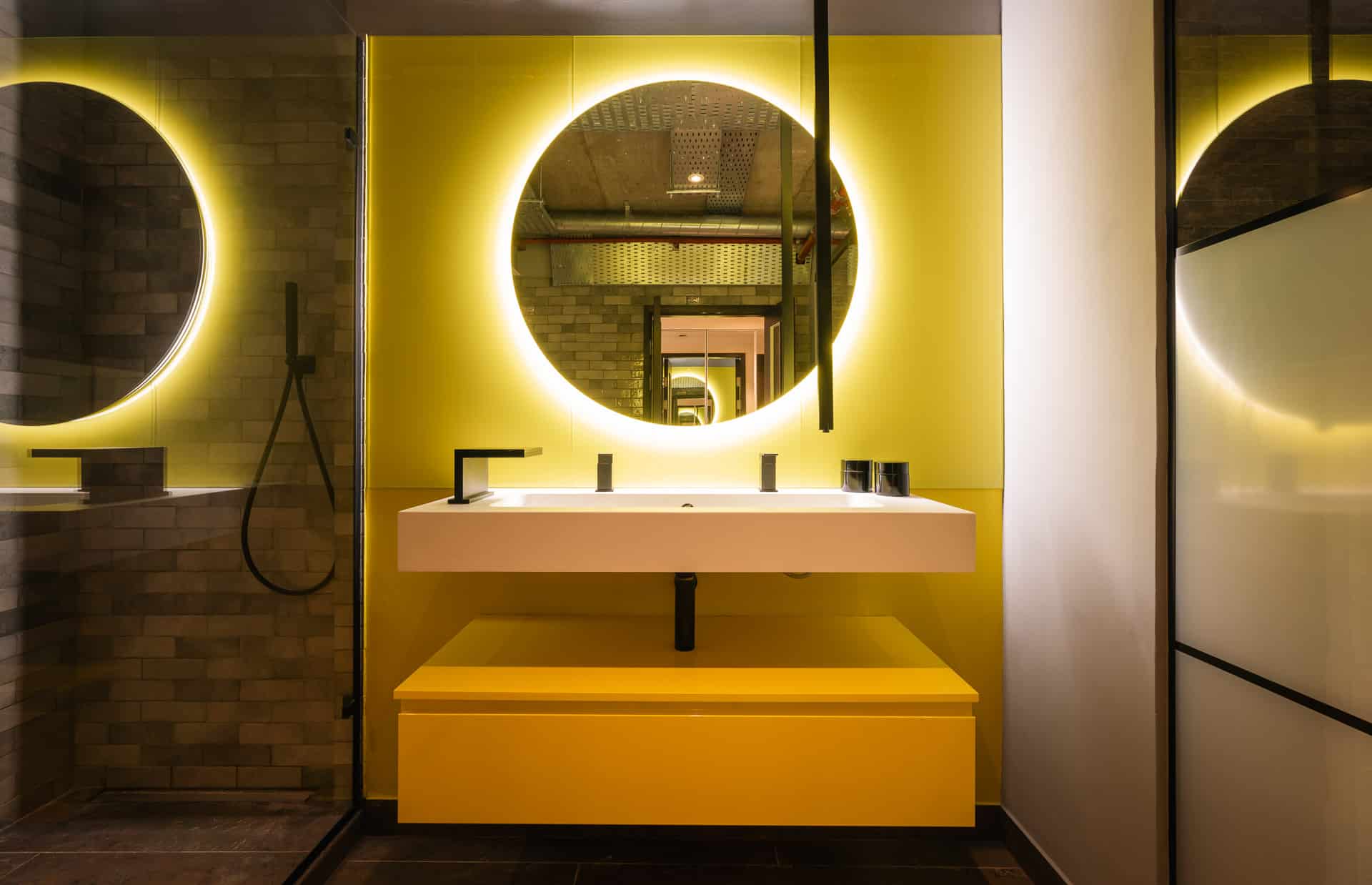 Versatile Bathroom with circular mirror and yellow background